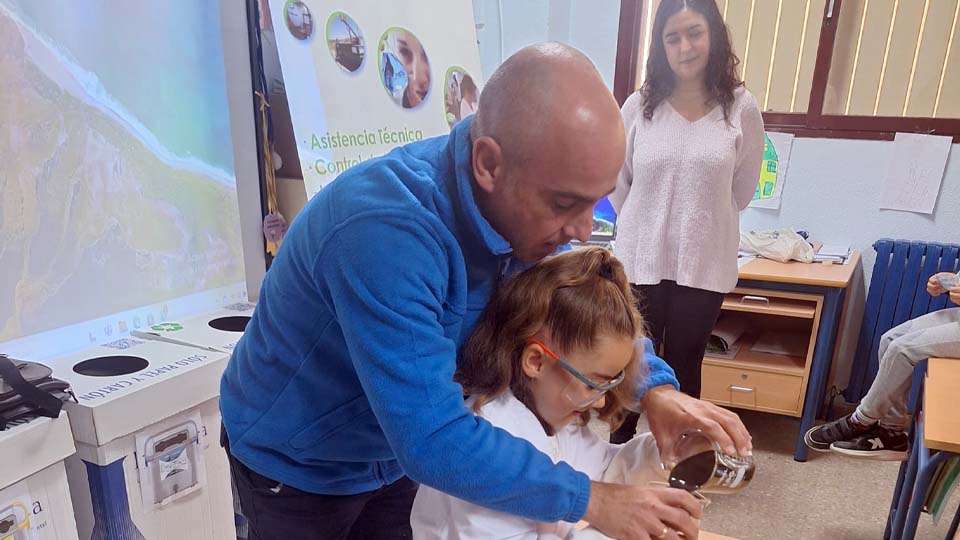 Profesor ayuda a alumna en experimento científico