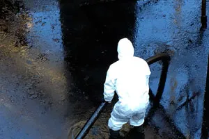 Persona con traje protector bajando escaleras oscuras