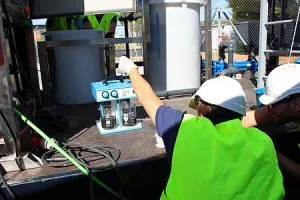 Operarios con cascos manejando maquinaria industrial