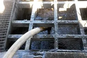 Rejilla industrial con agua residual y manguera