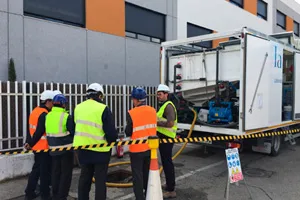 Trabajadores con chalecos reflectantes junto a camión industrial