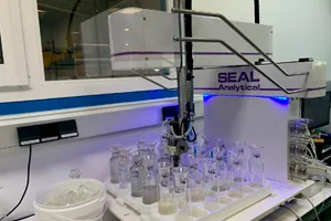 Brazo robótico de laboratorio manipulando vasos de vidrio