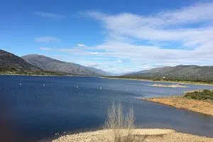 Embalse rodeado de montañas bajo cielo azul